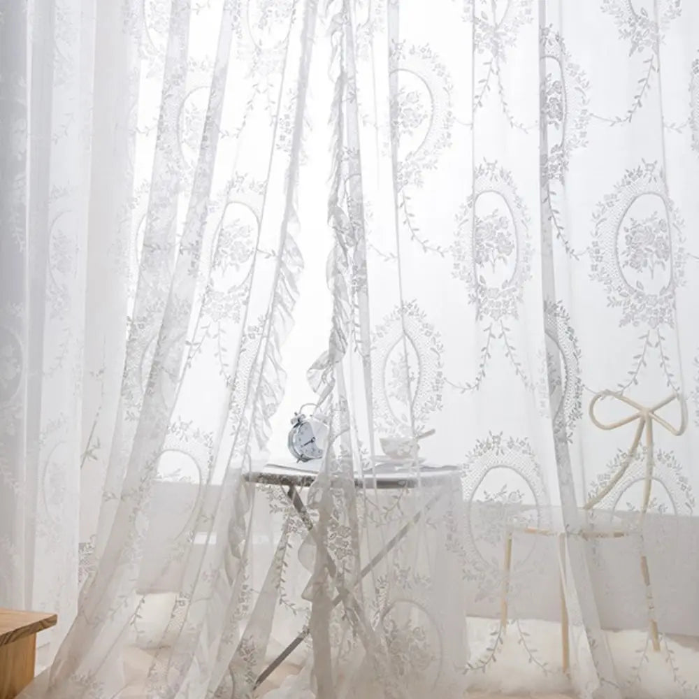 Sheer white floral lace curtains draped in a soft, romantic style