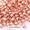 A pile of rose gold star-shaped acrylic beads for jewelry making