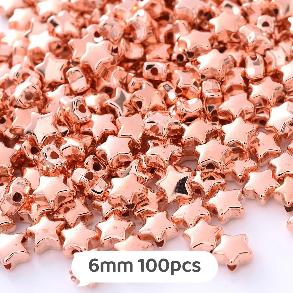 A pile of rose gold star-shaped acrylic beads for jewelry making