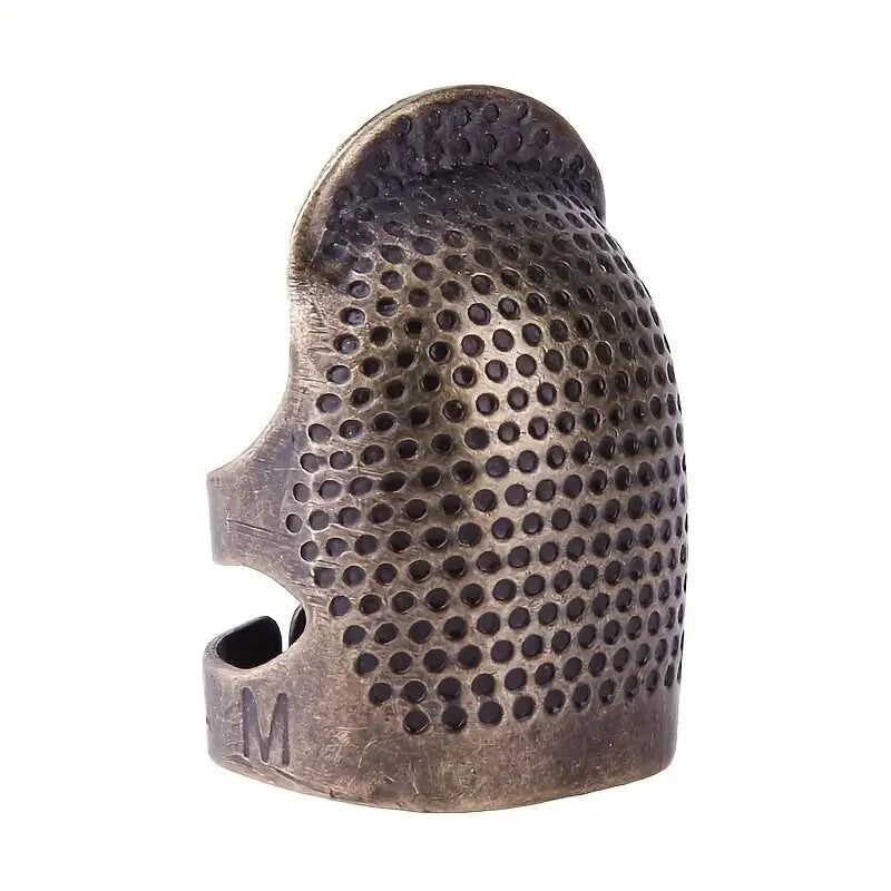 A vintage antique sewing thimble and needle protector set made of dark metal with a perforated surface.