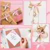 A collection of pink and gold satin ribbon twist tie bows used for gift wrapping and decoration.