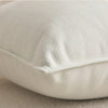A close-up of a cream-colored luxury chenille throw pillow cover showing its textured fabric detail.