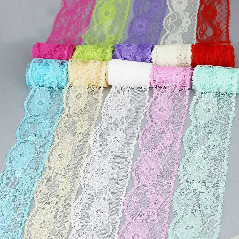 A collection of decorative lace ribbon rolls in various shades of pink, purple, green, and blue.