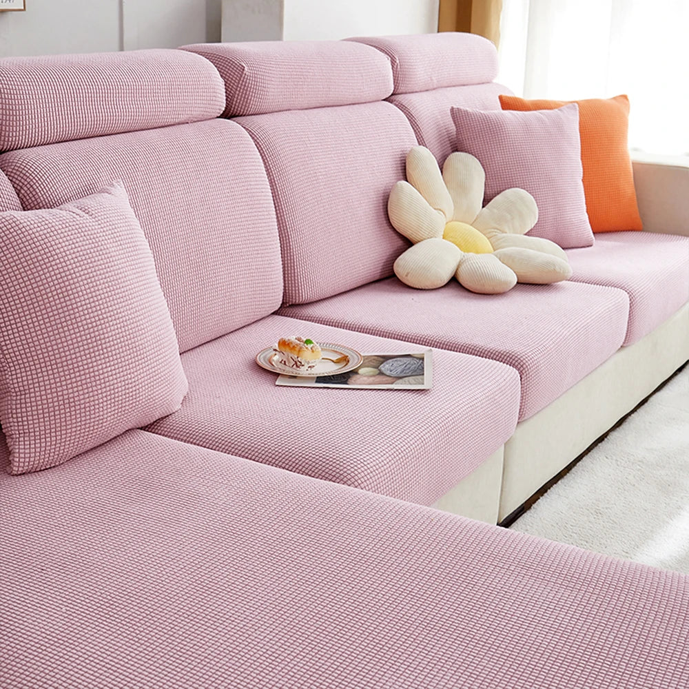 A pink polar fleece jacquard sofa seat cushion cover with matching pillows and a decorative flower cushion.