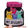 A collection of colorful embroidered letter patches featuring various animal faces on a black fabric background.