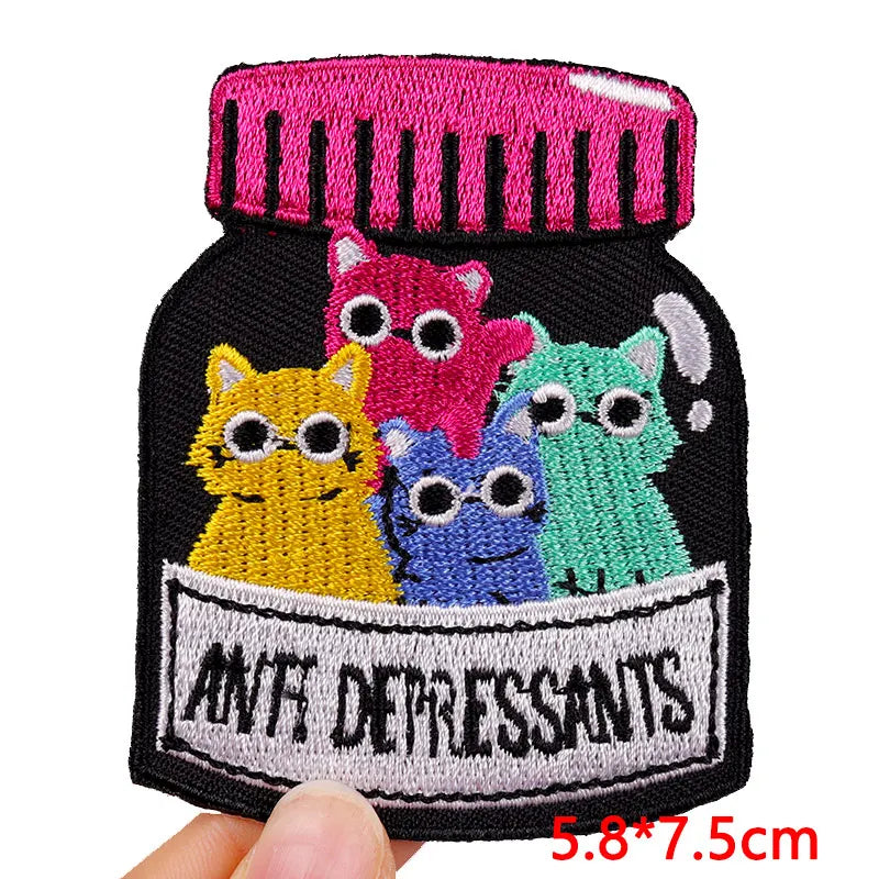 A collection of colorful embroidered letter patches featuring various animal faces on a black fabric background.