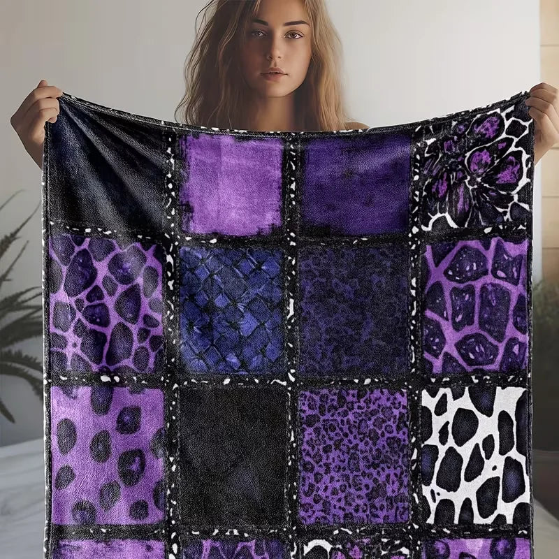 A dark purple and black flannel throw blanket featuring vibrant leopard print stitching.