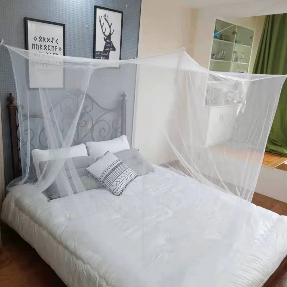A white mosquito net is draped over a bed in a bedroom, providing protection.