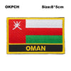 Embroidered patch of the flag of Oman featuring red, white, and green horizontal stripes with the word OMAN below.