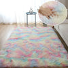 Rainbow plush area rug with pastel colors lying on a wooden floor near a window.