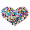 A heart shape composed of mixed size hotfix glass rhinestones in various colors like blue, green, purple, and red.