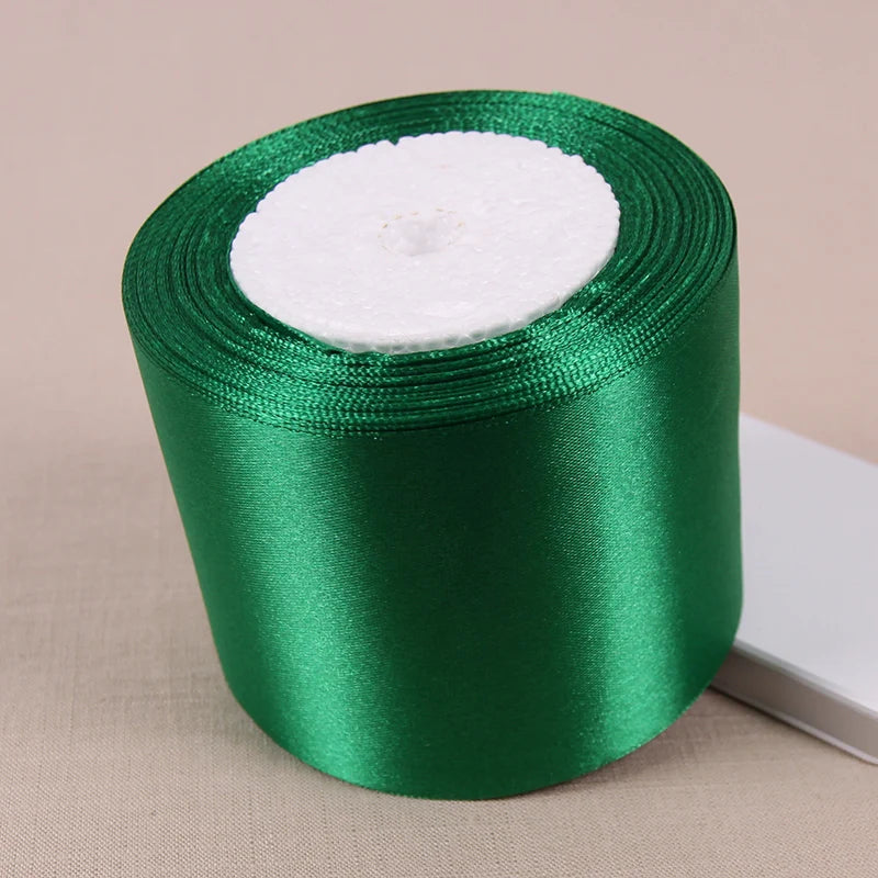 A roll of green satin ribbon used for crafting and decoration.
