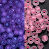 A close-up view of a 600-pack of 3mm glow-in-the-dark glass seed beads in various shades of purple and pink.
