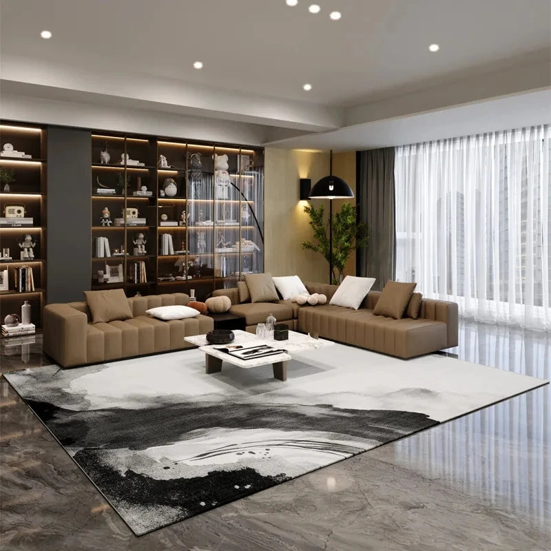 A modern living room featuring a black and white geometric area rug on a polished floor.