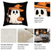 A black pillow featuring a white ghost with an orange pumpkin and a yellow hat design