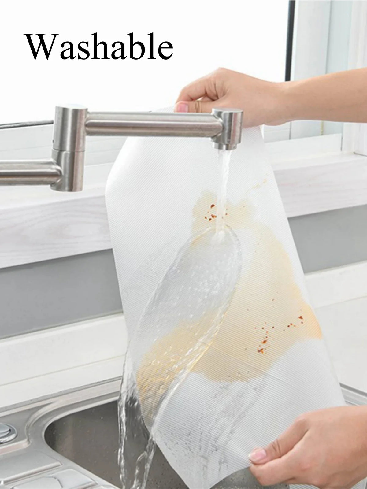 A hand is pouring water over a white silicone fridge and drawer liner to demonstrate its washable feature.