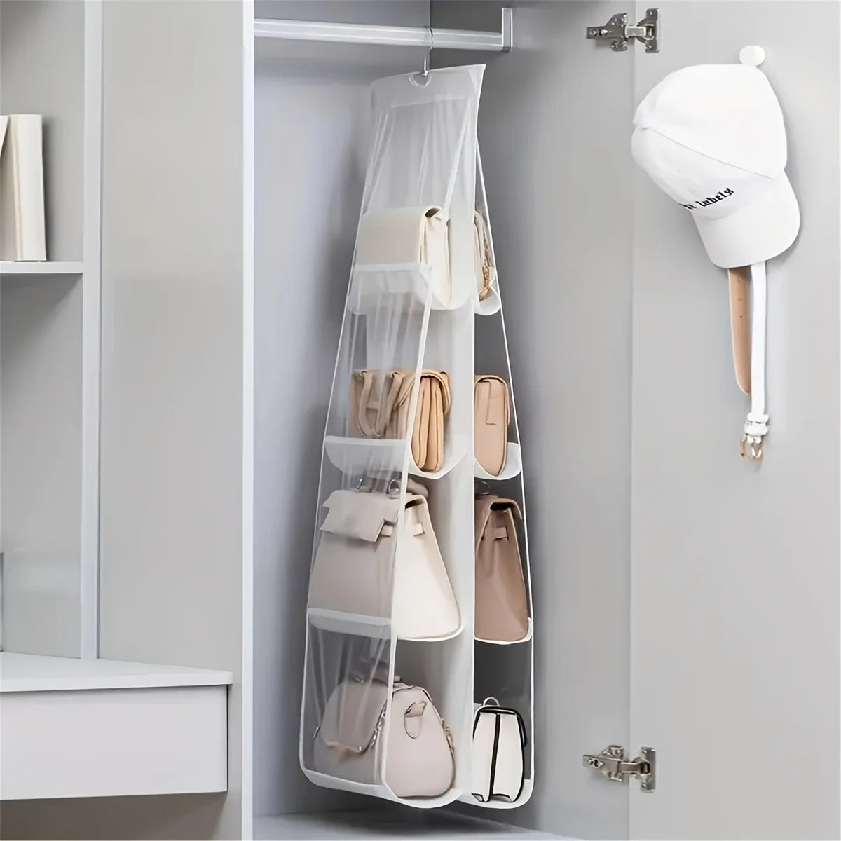 A double-sided hanging closet organizer bag with various light beige and pink bags displayed on a white shelf inside a gray c