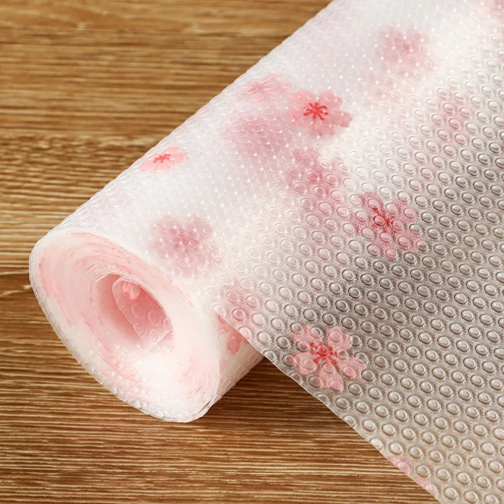 Roll of reusable fridge and cabinet liner pads with pink floral designs
