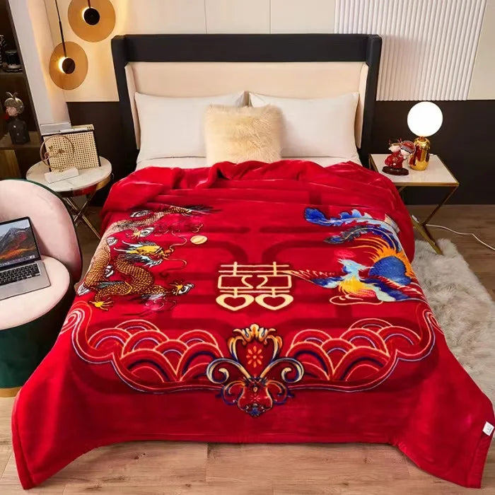 A vibrant red blanket with intricate rose and peony floral patterns is displayed on a bed.