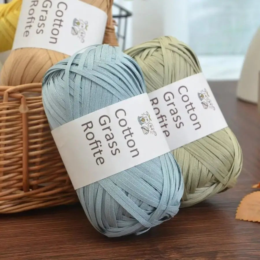 A set of natural cotton grass yarn skeins in light blue and sage green colors.