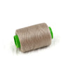 A roll of beige sewing threads with green plastic casing.