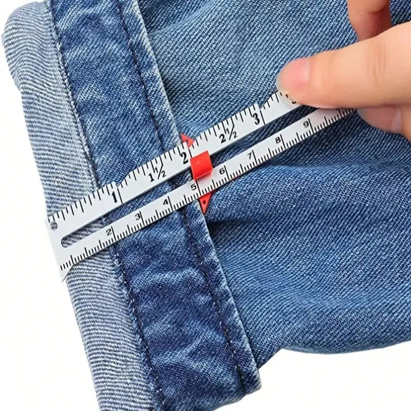 A hand uses a precision metal sliding sewing gauge to measure fabric on denim clothing.