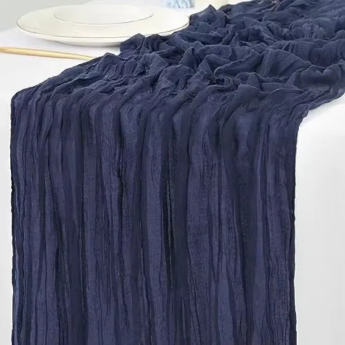 Dark navy rustic gauze table runner draped elegantly on a white plate.