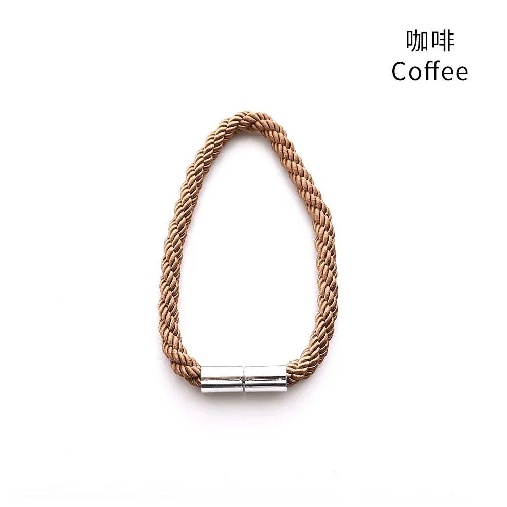 A braided cord magnetic curtain tieback clip in a natural tan color.