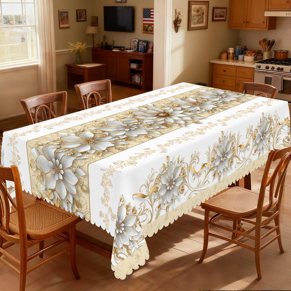 A white tablecloth with a beige and gold floral pattern is displayed on a wooden table in a bright room.