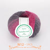A ball of multi-colored wool yarn with shades of pink, purple, and gray.