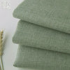 Stack of olive green coarse linen and cotton fabric rolls