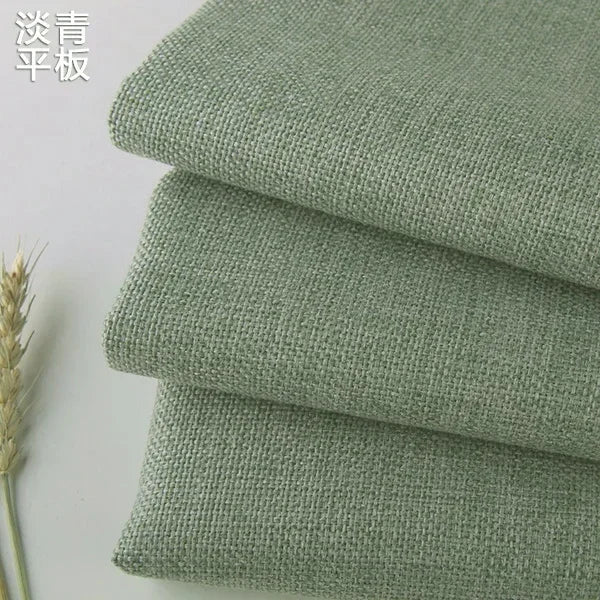 Stack of olive green coarse linen and cotton fabric rolls