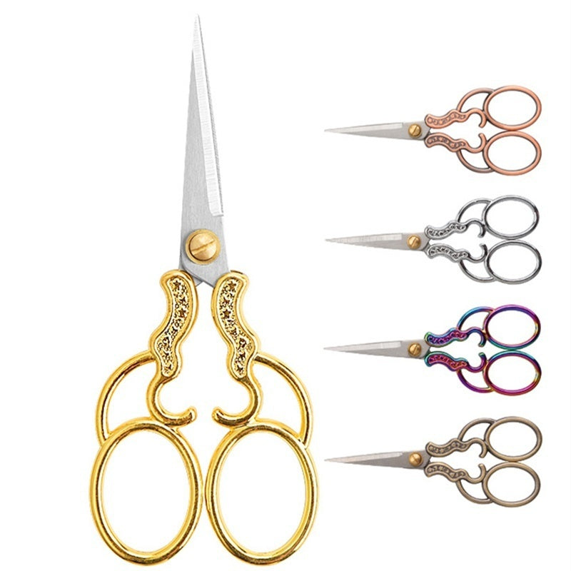 A set of vintage stainless steel sewing scissors with various sizes and decorative handles.