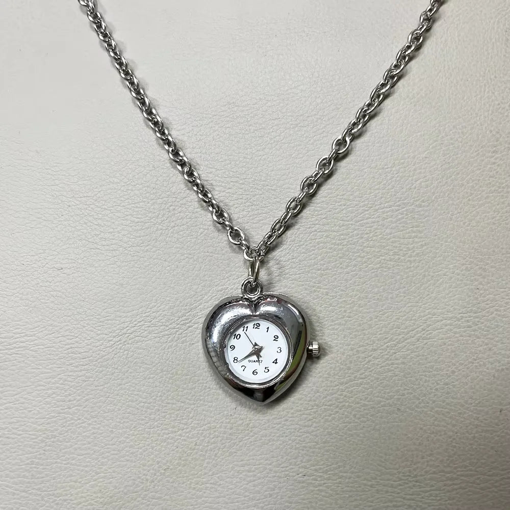 Silver chain necklace with a heart-shaped pocket watch charm featuring an adjustable clock face