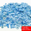 A pile of assorted light blue resin sewing buttons for crafting and DIY projects