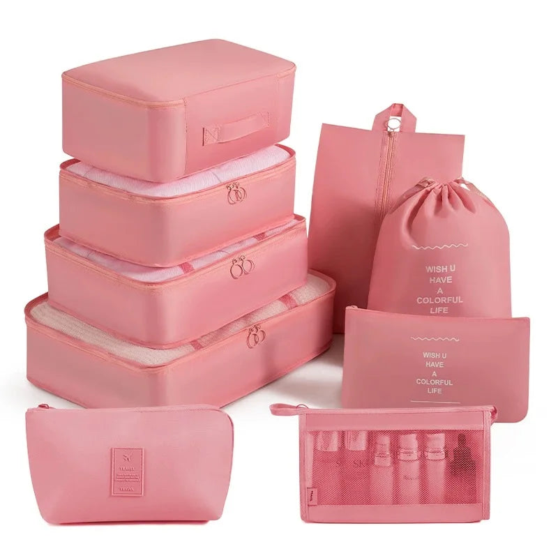 A set of pink travel storage organizers including a box, pouches, and cosmetic bags.