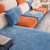 A modern sofa covered in blue fabric and orange cushions with a white full backrest.