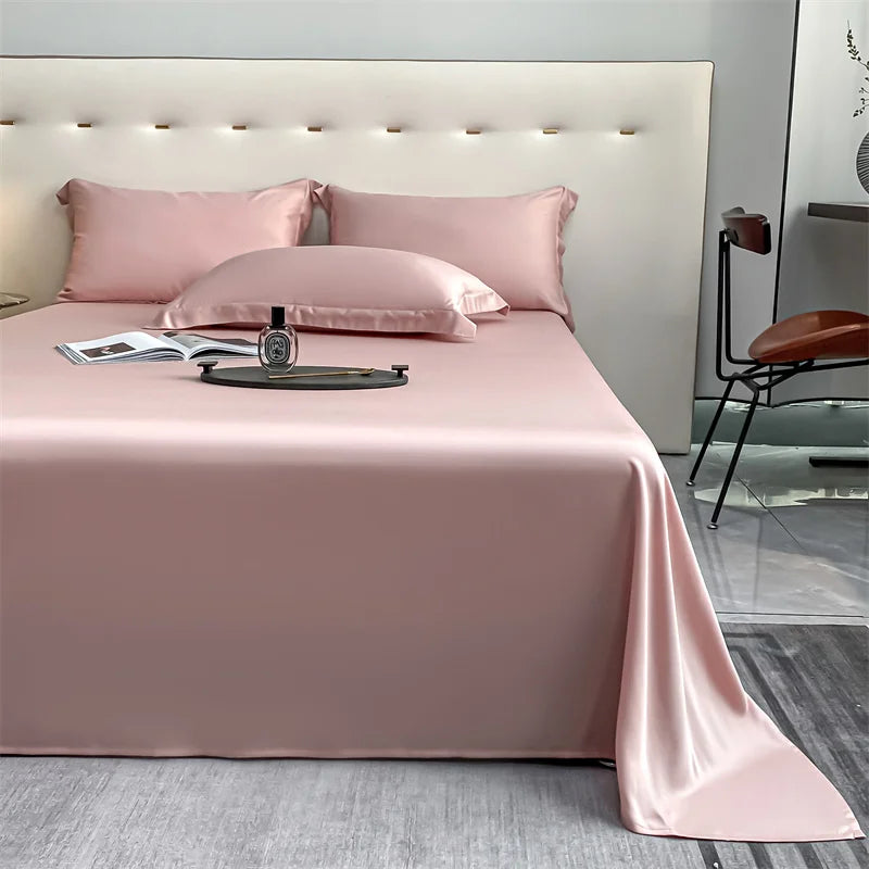 Pink luxury bamboo flat sheets displayed on a bed with pillows and a watch.