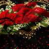 A close-up of a bouquet of deep red roses surrounded by white flowers and gold accents on a dark background.