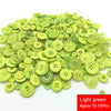 A pile of light green resin sewing buttons for crafting and DIY projects