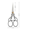 Vintage stainless steel sewing scissors with a pointed blade and decorative handles