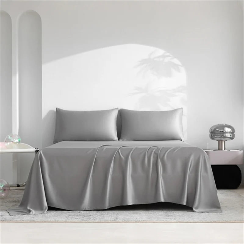 A luxury organic bamboo bed sheet set draped on a bed in a bright, minimalist room.