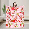 A pink plaid throw blanket featuring a pattern of strawberry shortcake characters and fruit.