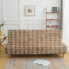 A beige velvet non-slip armless sofa cover displayed on a wooden floor with a patterned rug.