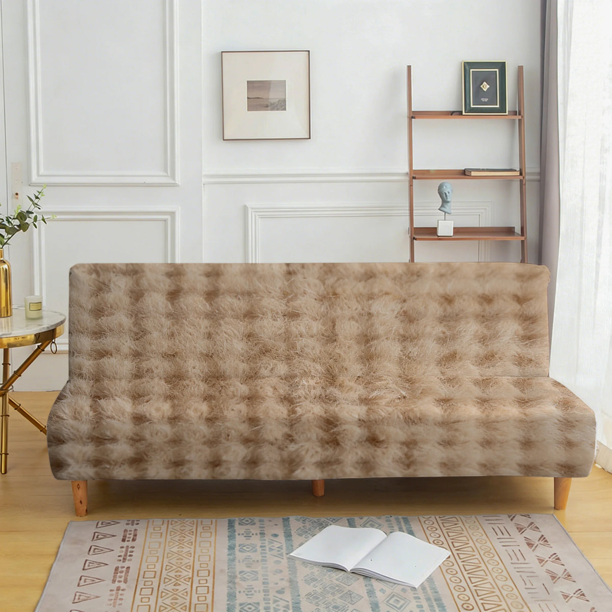A beige velvet non-slip armless sofa cover displayed on a wooden floor with a patterned rug.
