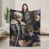 A graphic throw blanket featuring a collage of several male characters in dark and muted tones.