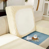 A light cream jacquard sofa slipcover with elastic edges featuring a large white rectangular panel and a blue accent cushion.