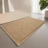 A rectangular beige waffle design non-slip bathroom mat placed on a light gray floor.