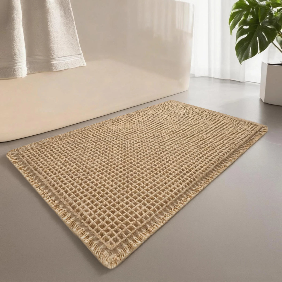 A rectangular beige waffle design non-slip bathroom mat placed on a light gray floor.