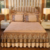 A beige bed skirt set with matching pillowcases and a tan quilted bedspread on a wooden bed frame.